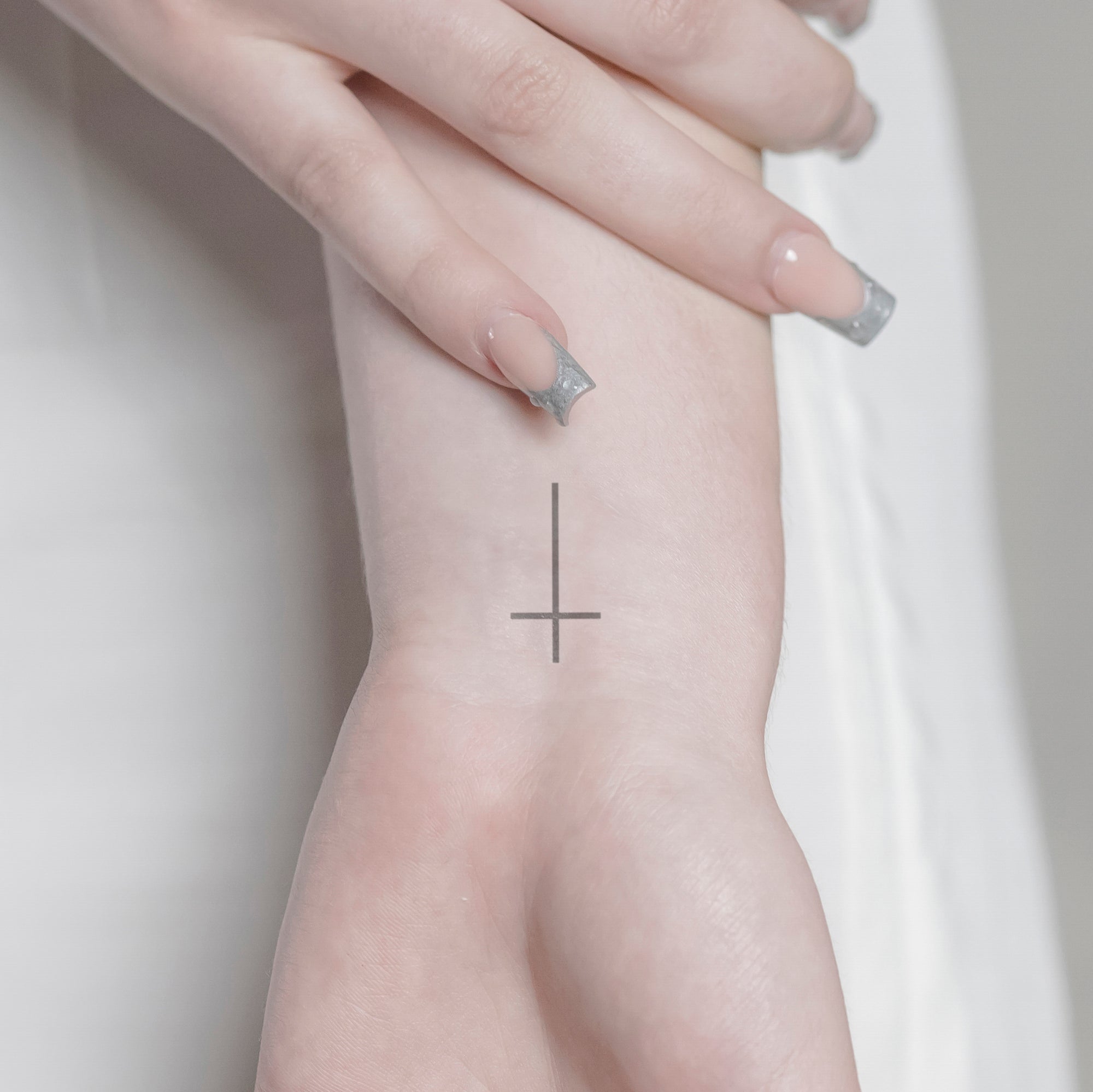 Kleines Kreuz Tattoo von minink, der Marke für temporäre Tattoos.