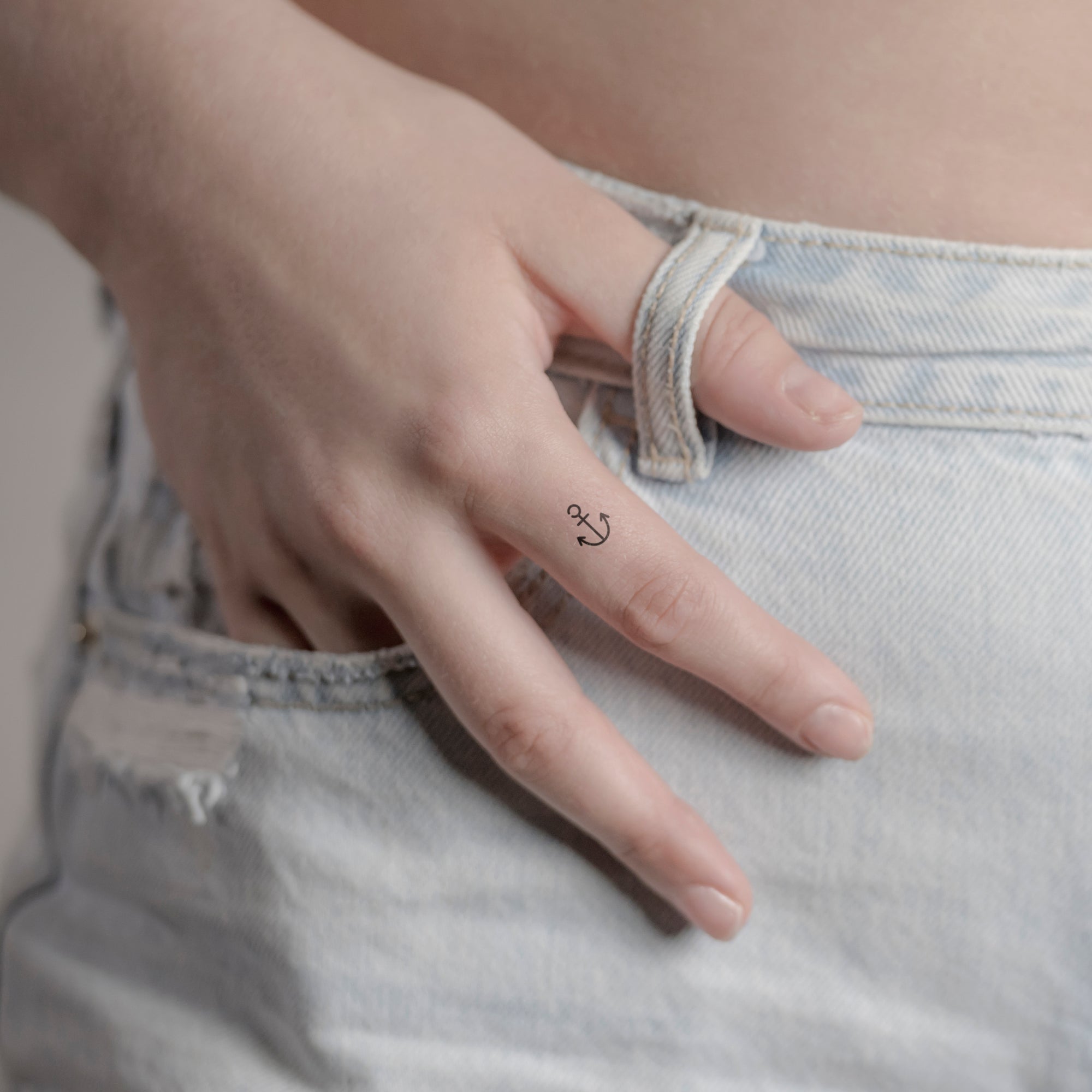 Kleiner minimalistischer Anker Tattoo von minink, der Marke für temporäre Tattoos.