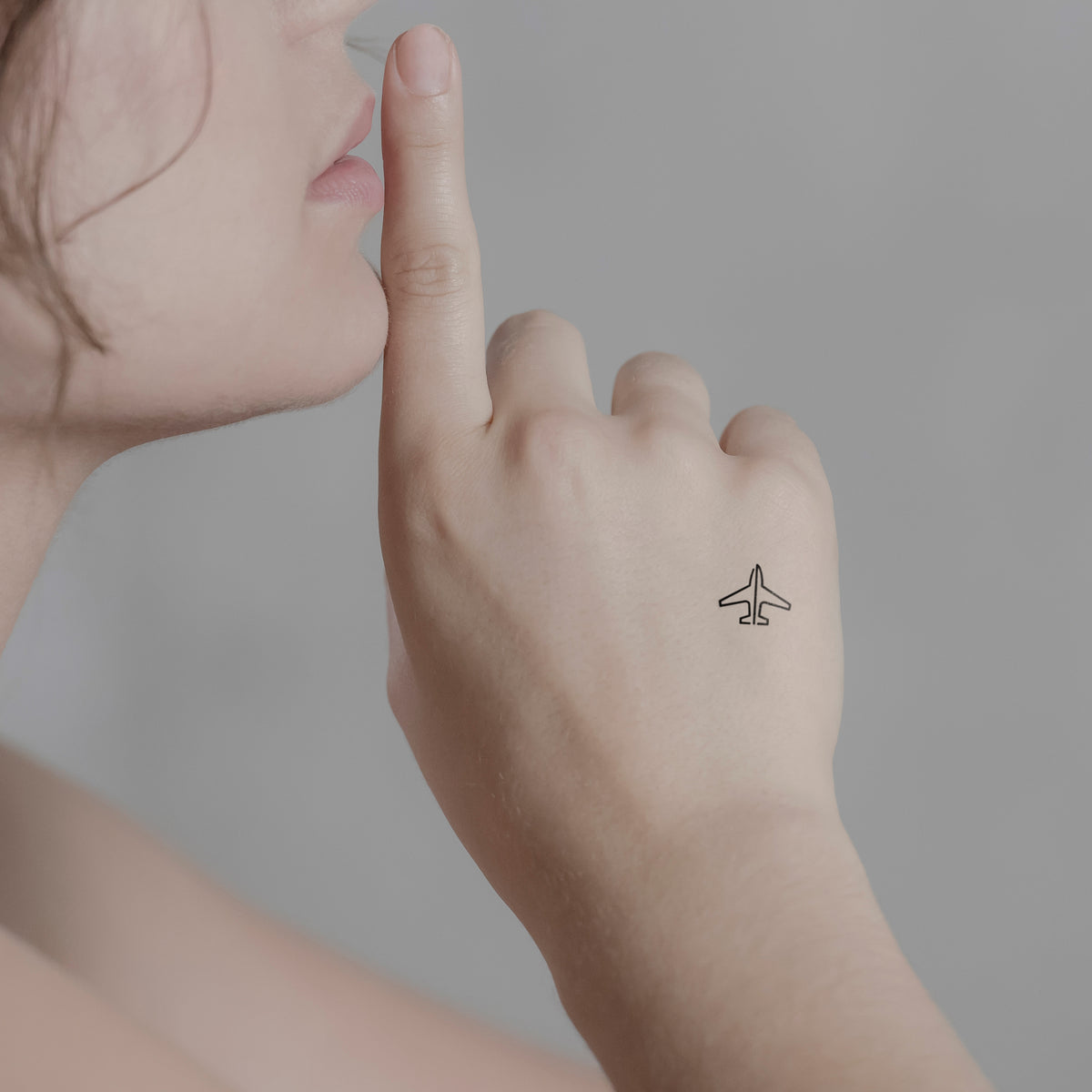 Minimalistisches Flugzeug Tattoo von minink, der Marke für temporäre Tattoos.