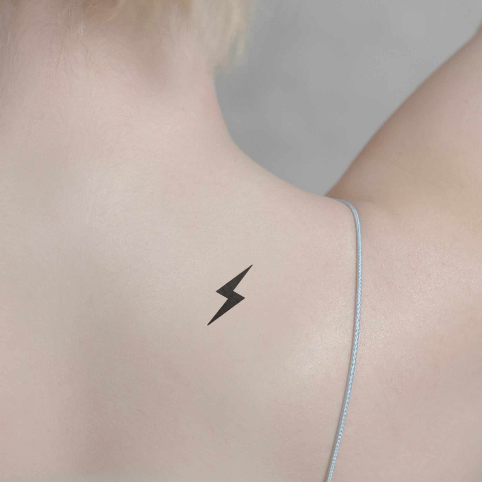 Tiny lightning bolt tattoo on the ankle.