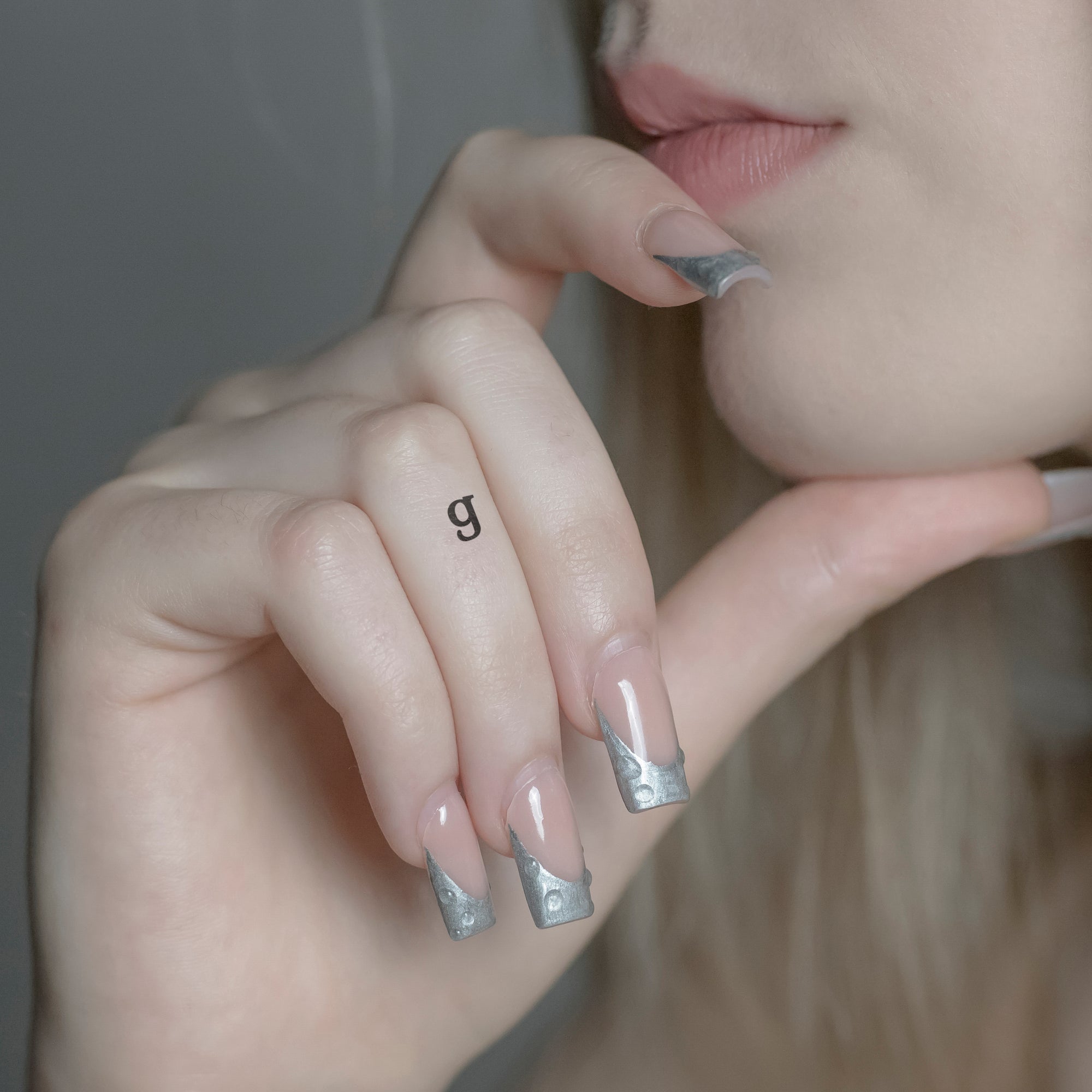 Schriftzug Tattoo Kleinbuchstabe: g von minink, der Marke für temporäre Tattoos.