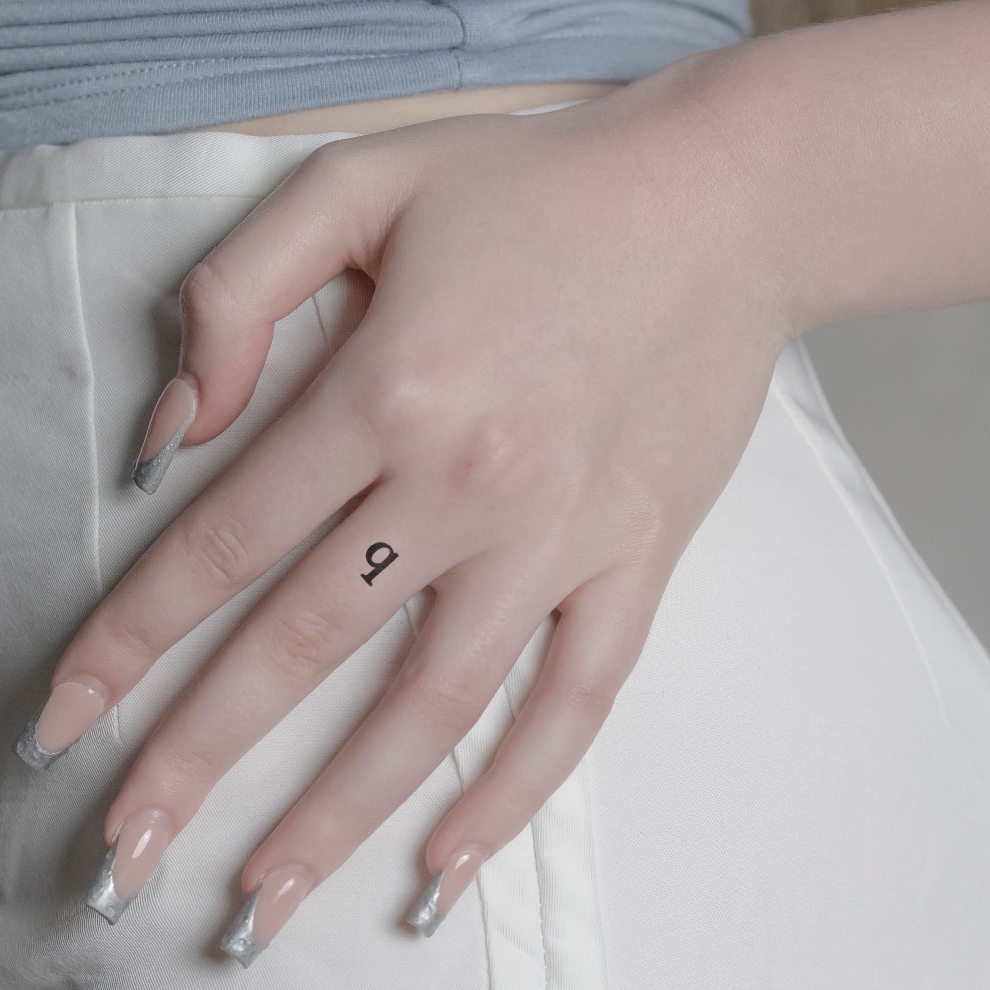 Schriftzug Tattoo Kleinbuchstabe: q von minink, der Marke für temporäre Tattoos.