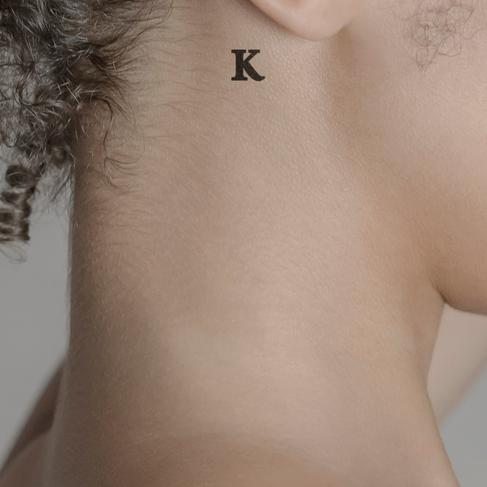 Schriftzug Tattoo Grossbuchstabe: K von minink, der Marke für temporäre Tattoos.