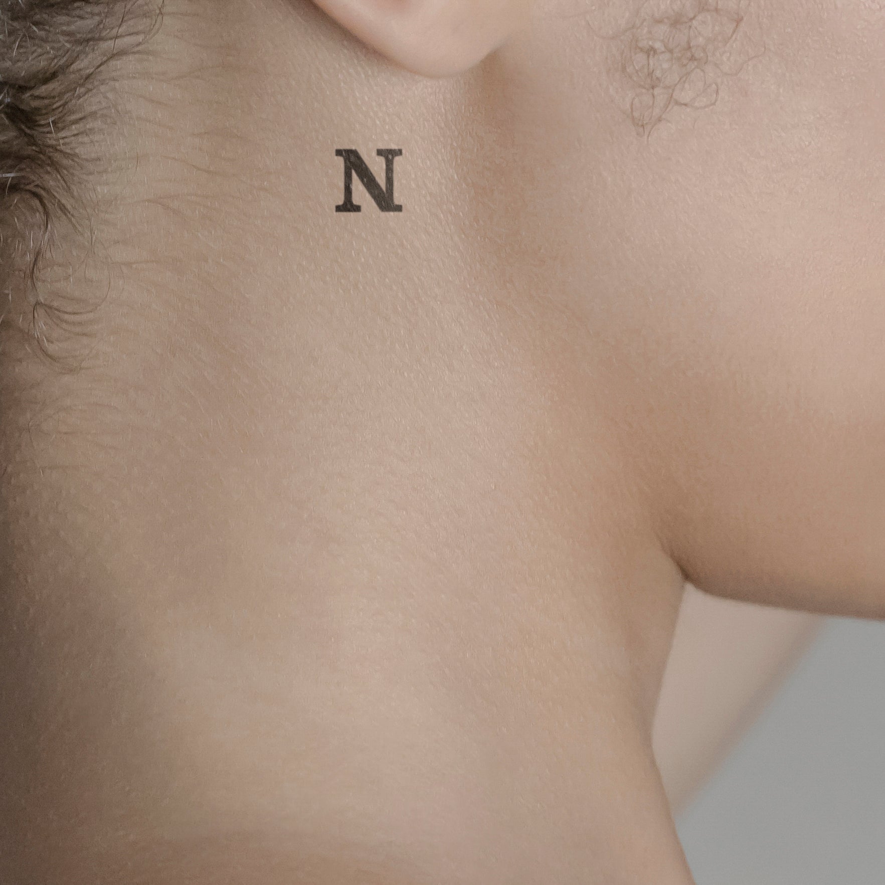 Schriftzug Tattoo Grossbuchstabe: N von minink, der Marke für temporäre Tattoos.