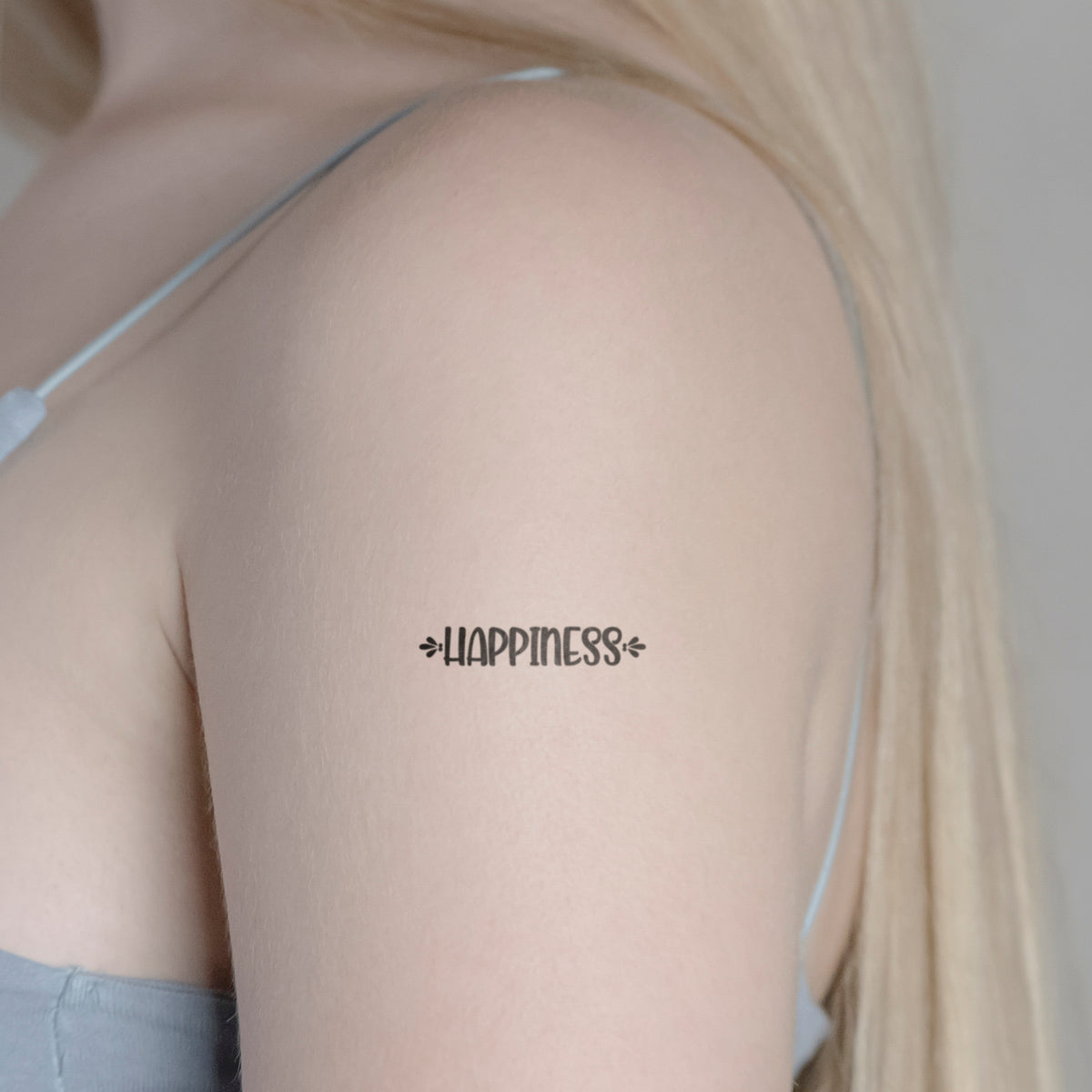 Schriftzug Tattoo HAPPINESS von minink, der Marke für temporäre Tattoos.