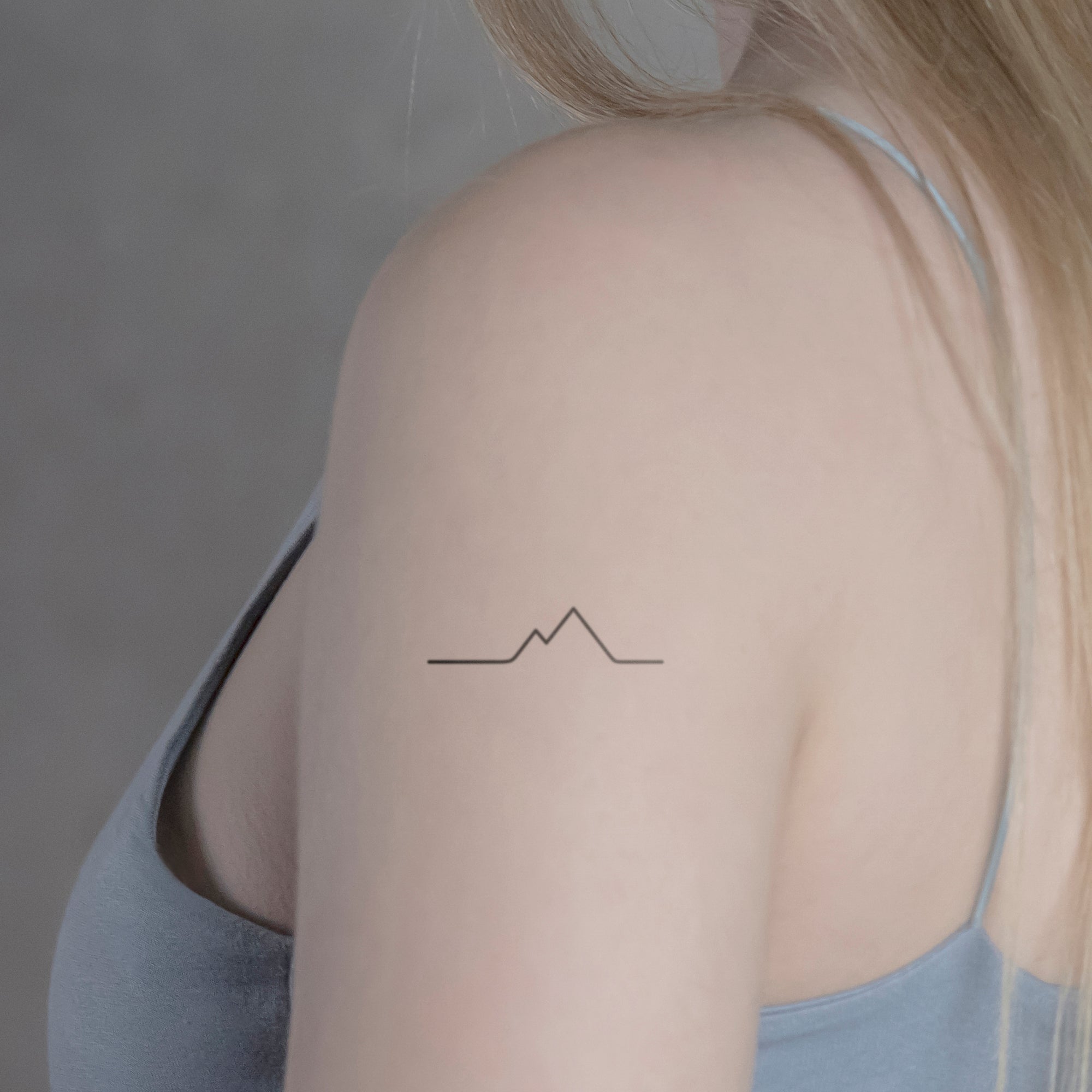 Cubist mountain range tattoo on chest and shoulder.