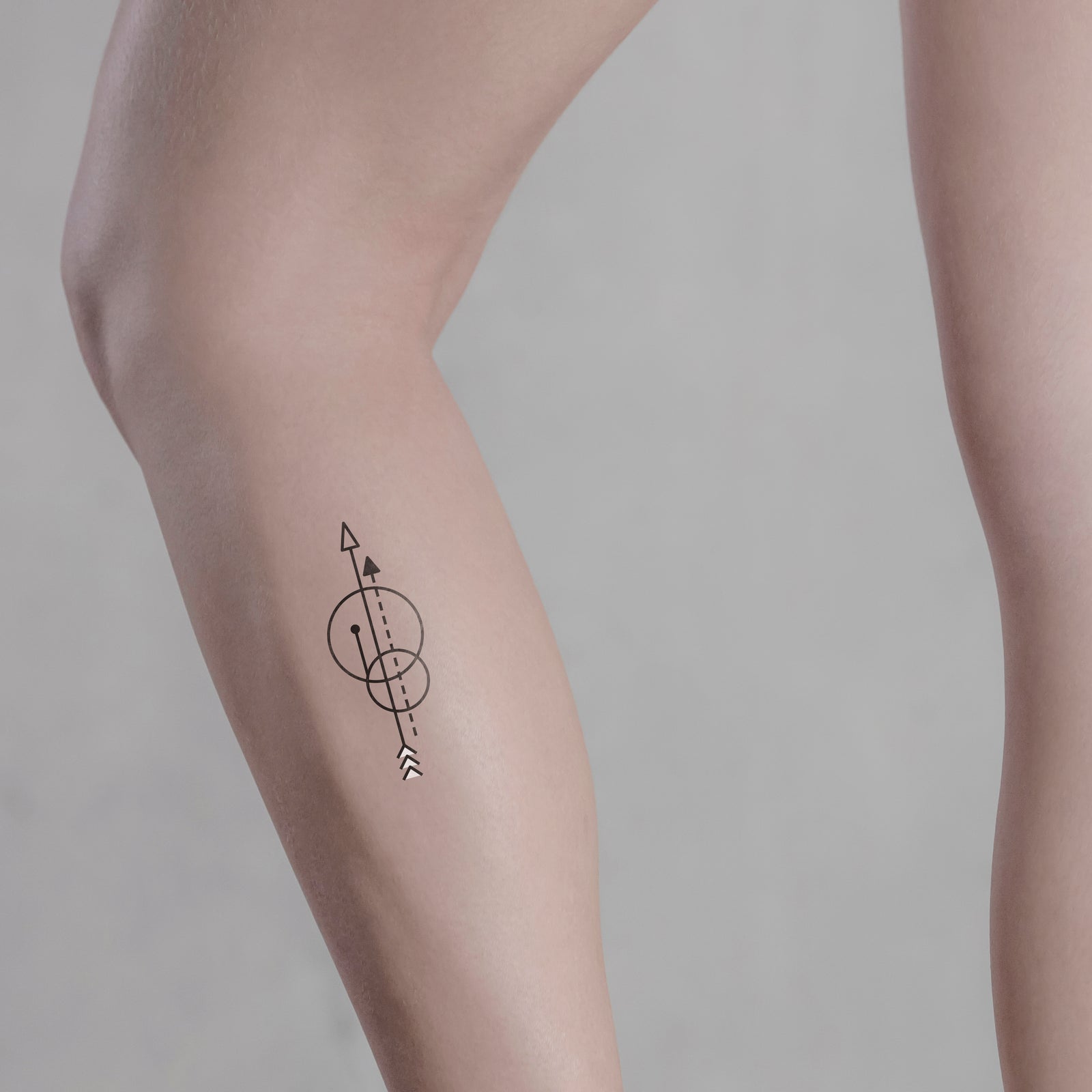 Small arrow tattoo on the Achilles heel.