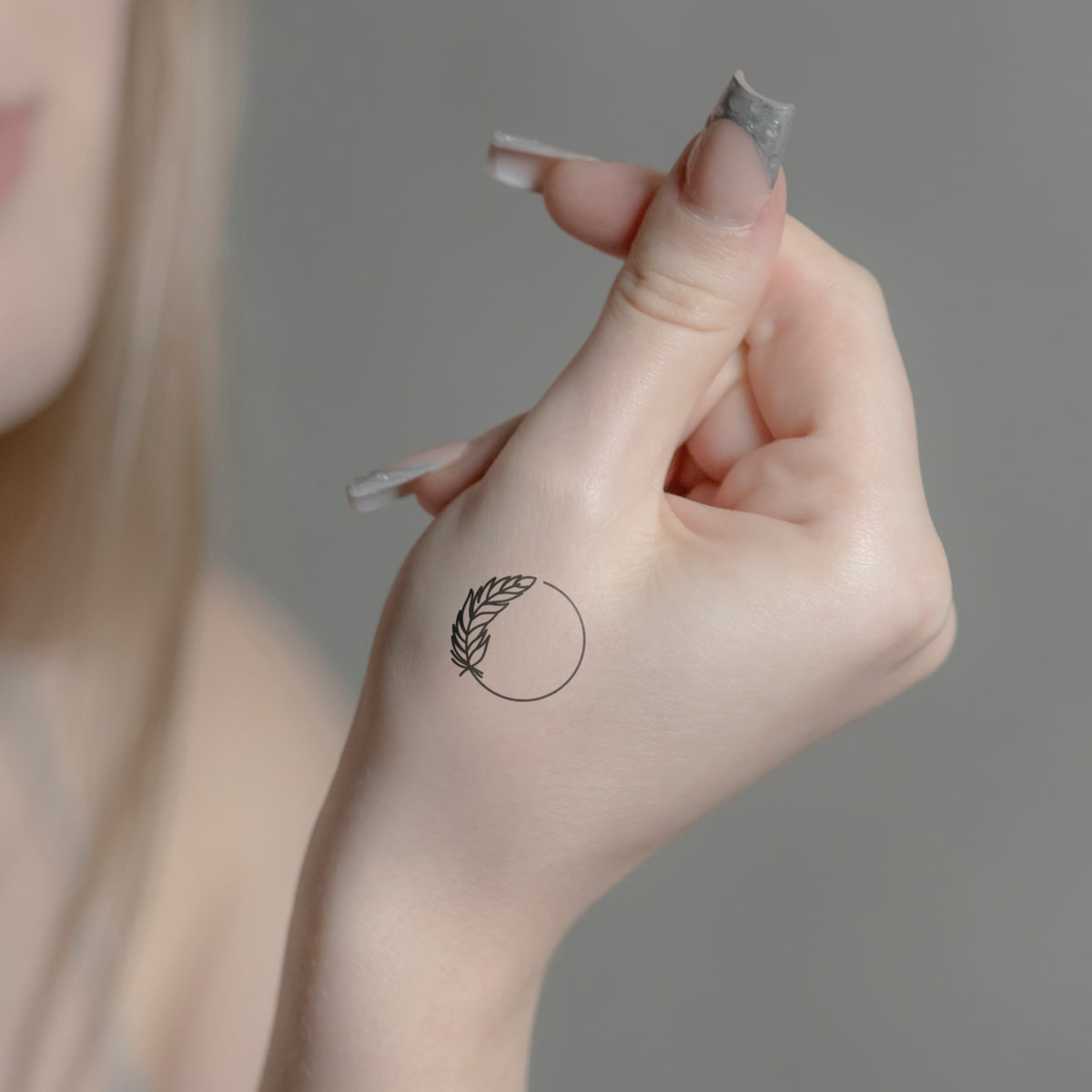 Feder mit Kreis Tattoo von minink, der Marke für temporäre Tattoos.
