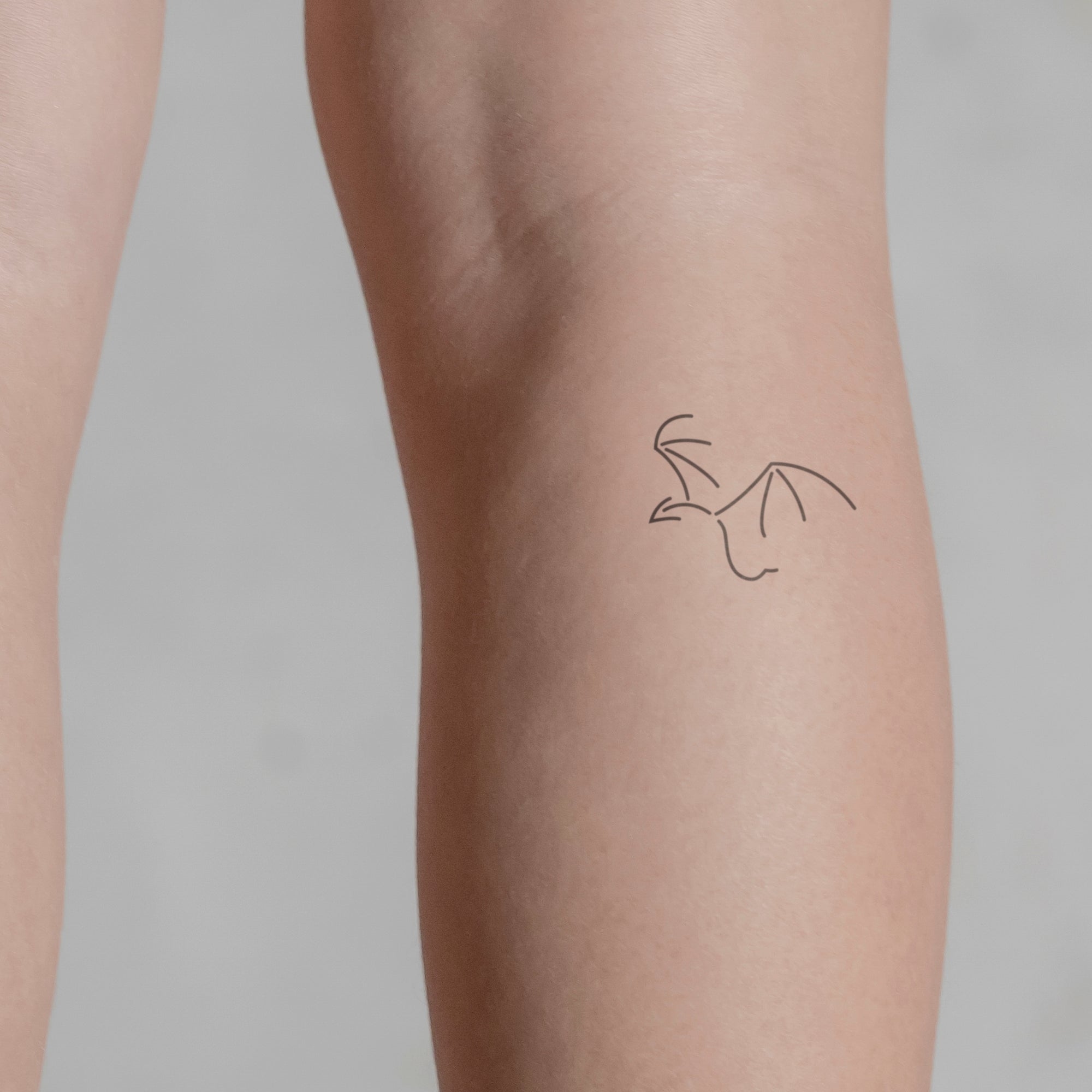 Minimalistischer Drache Tattoo von minink, der Marke für temporäre Tattoos.