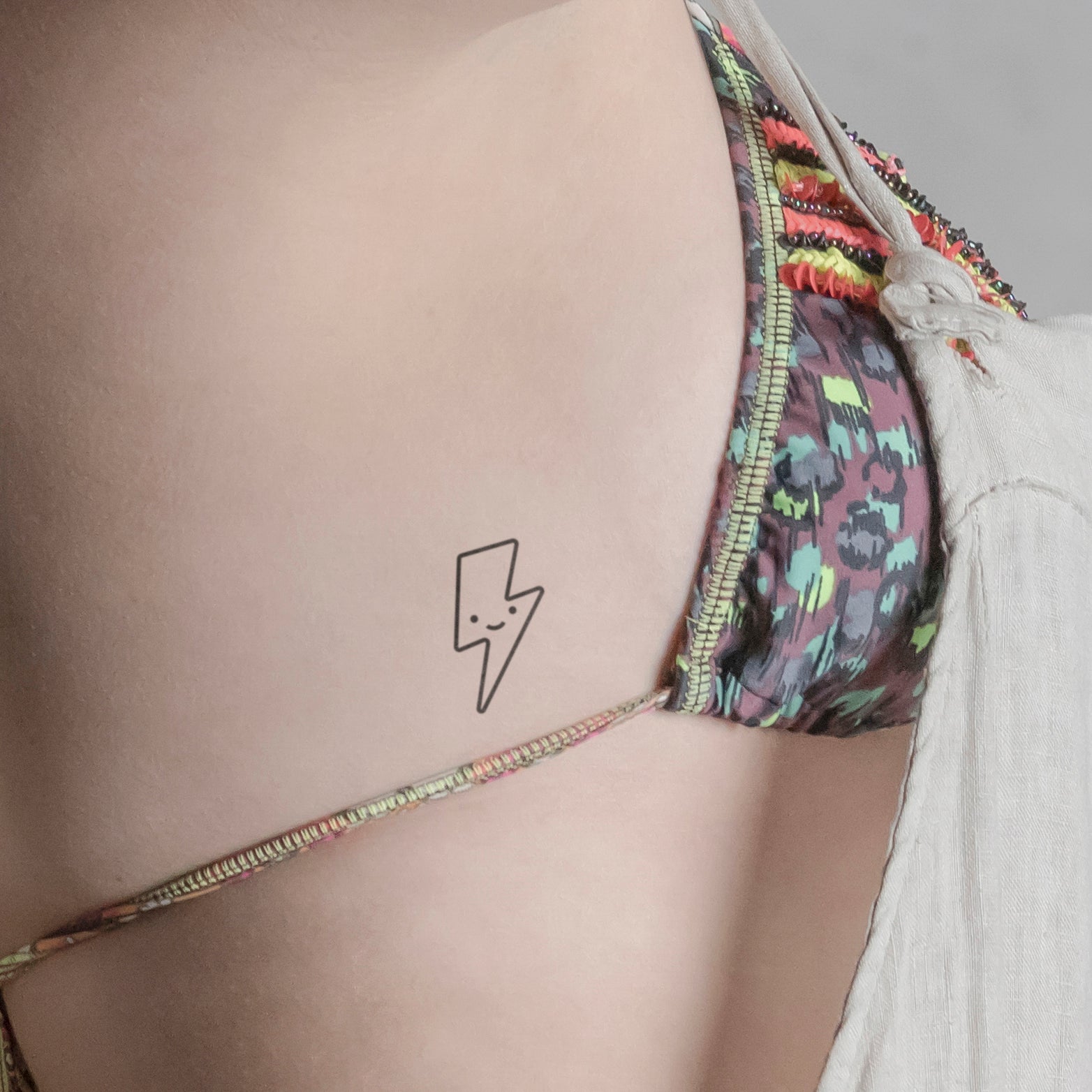 Lächelnder Blitz Tattoo von minink, der Marke für temporäre Tattoos.