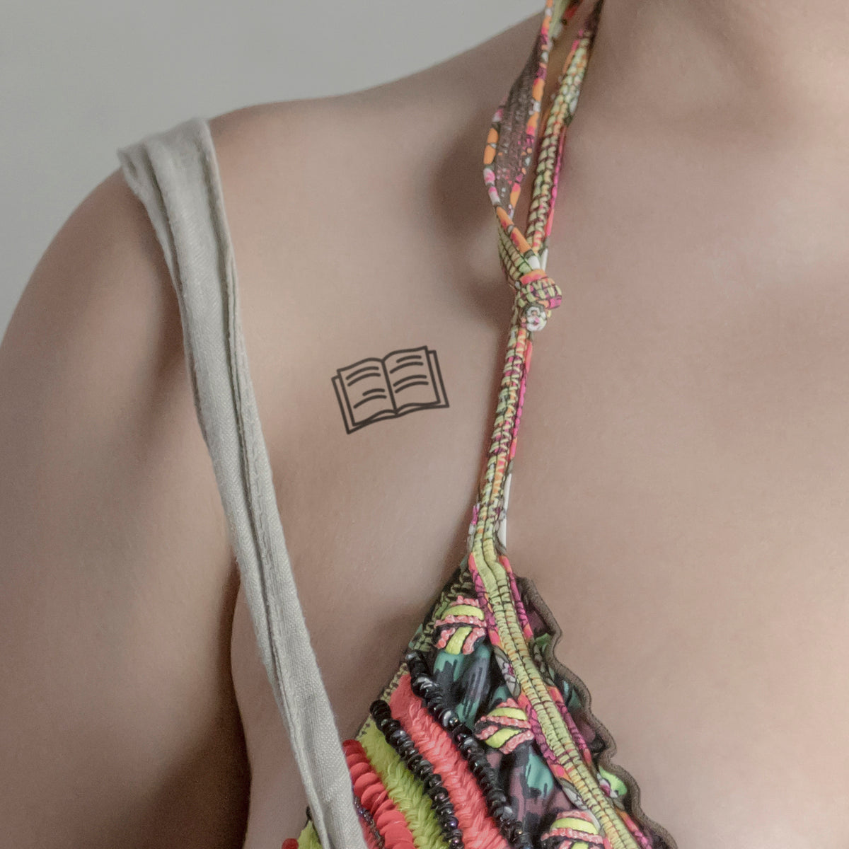Buch mit Zeilen Tattoo von minink, der Marke für temporäre Tattoos.