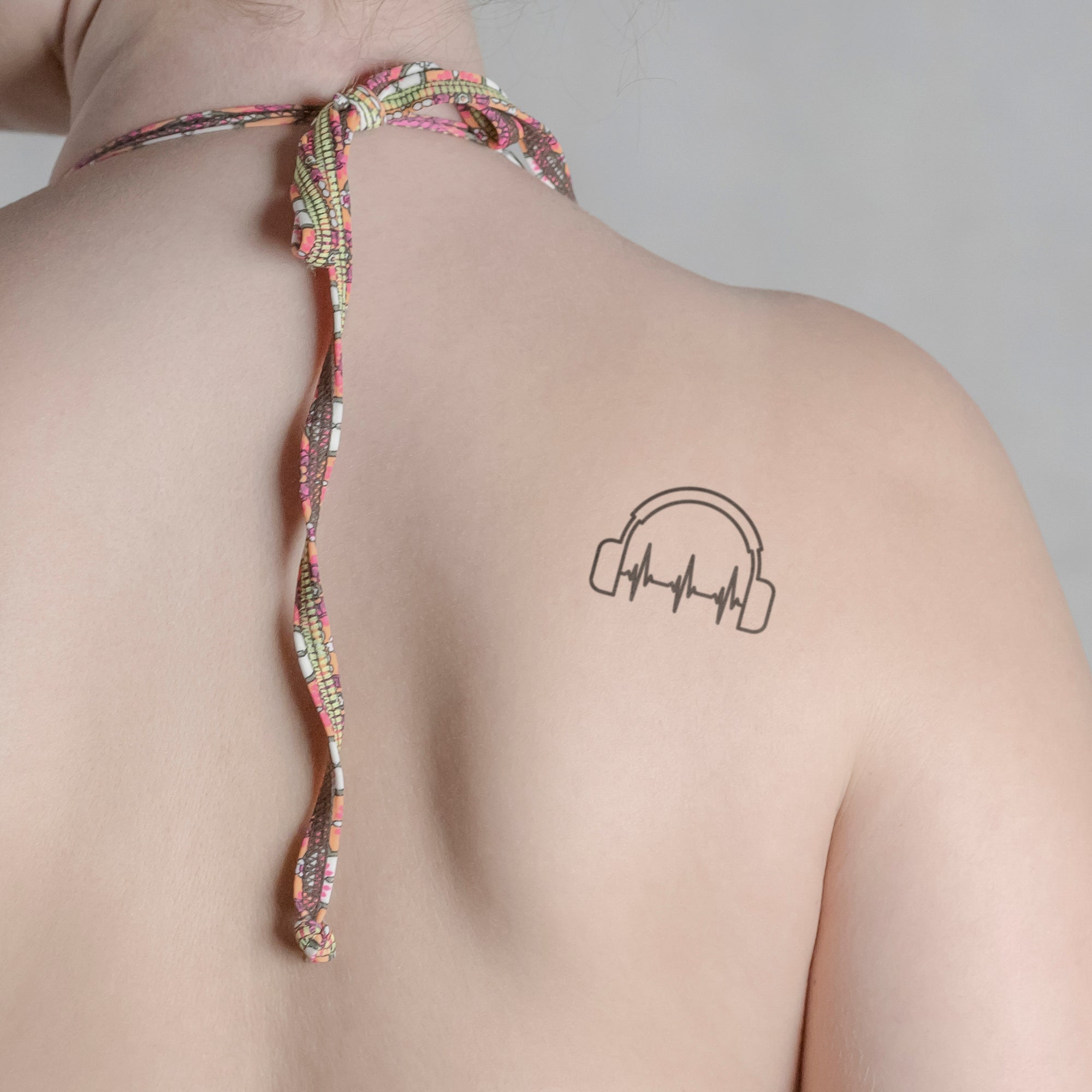 Kopfhörer mit Herzschlag Tattoo von minink, der Marke für temporäre Tattoos.