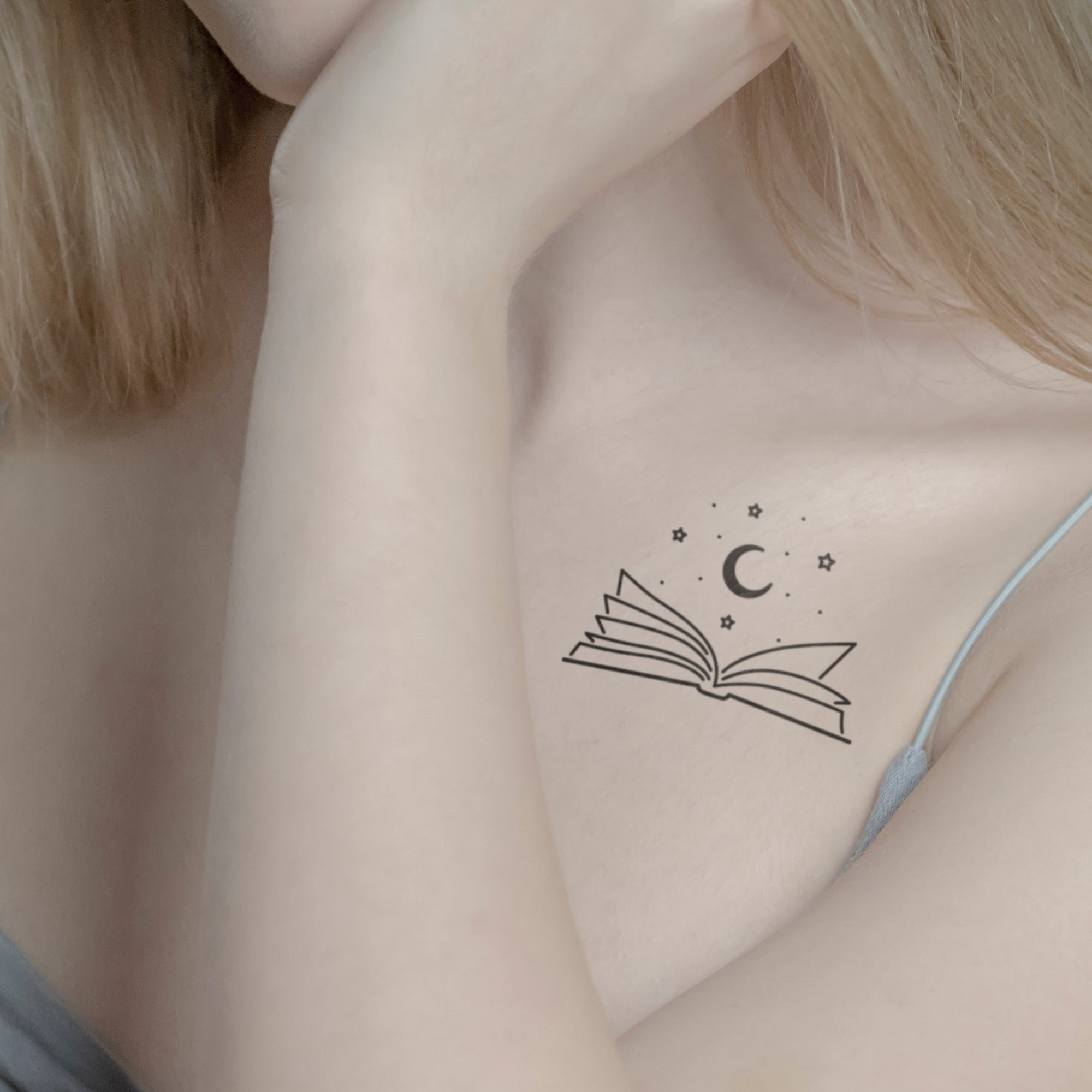 Offenes Buch mit Mond Tattoo von minink, der Marke für temporäre Tattoos.